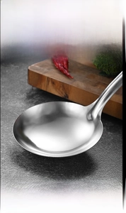 Macro shot of deep stainless steel soup ladle with high-gloss mirror finish design