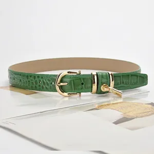 Chic emerald green croc-embossed leather belt with golden horseshoe buckle and charm