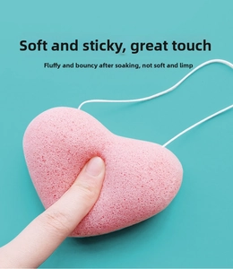 Macro shot of soft pink heart-shaped konjac sponge showing fine texture and resilience