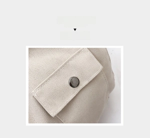 Vue macro détaillée du bouton-pression sur un sac fourre-tout en toile de couleur crème