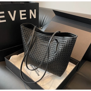 Close-up of black woven tote bag with premium texture and matching gift box packaging