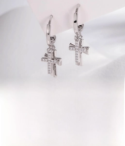 Macro shot of silver cross hoop earring featuring micro-pave cubic zirconia details