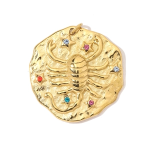 Macro view of gold Scorpio pendant with colorful rhinestones and embossed details