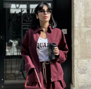 Detail of burgundy vintage jacket and drawstring shorts set in street style look