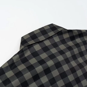 Detailed close-up of the collar and shoulder seams on the dark grey plaid shirt