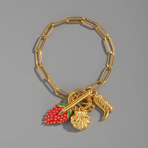 Détail d'un bracelet plaqué or 18K avec breloques fraise, coquillage et botte
