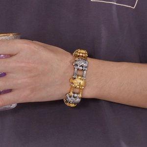 Detailed shot of two-tone gold and silver skull bracelet on man's wrist in rock style