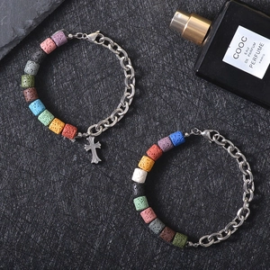 Titanium steel cross bracelet with colorful volcanic stone beads on textured background