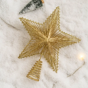 Sparkling gold glitter iron star tree topper with spiral base on snowy background