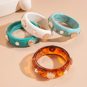 Vue détaillée de joncs en résine avec coquillages dorés et perles en turquoise et ambre
