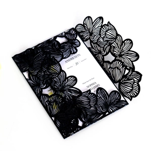 Detail of laser cut black wedding invitation sleeve with intricate hollow pattern