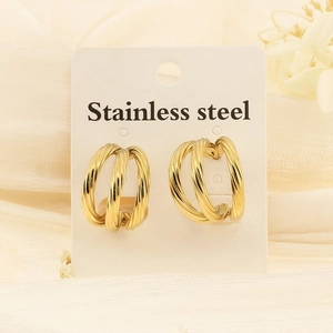 Detailed view of twisted C-shaped gold stainless steel earrings on a display card