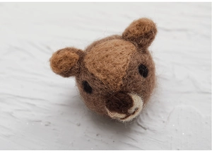 Macro detail of handmade wool felt animal head decoration with fine needle texture