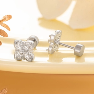Silver flower stud earrings with sparkling cubic zirconia on elegant ceramic surface