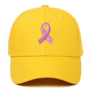 Detail of pink ribbon embroidery on bright yellow baseball cap with structured crown