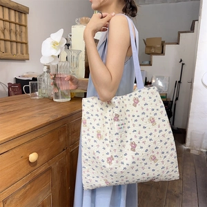 Close-up of quilted floral canvas tote with cute bear pattern and brand label detail