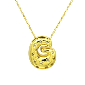 Close-up of a gold bubble letter G pendant with cubic zirconia inlay on a necklace