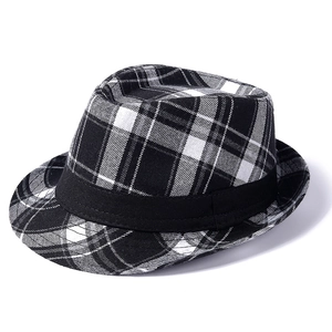Macro detail of black and white plaid fabric texture and black ribbon on fedora hat