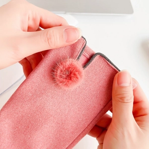 Detailed view of pink fleece gloves with touchscreen tips and fuzzy pompom decor