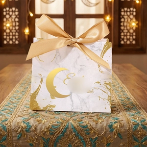 Detail of Eid Mubarak gift bag featuring white marble pattern and gold satin ribbon