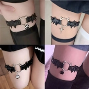 Detail of black PU leather bat wing garter with cat ear ring and hanging charms