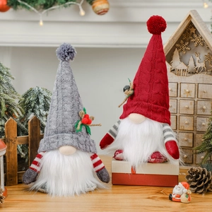 Glow Christmas gnomes with knitted hats and holly leaves in festive indoor setting