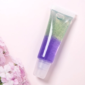 Detalle macro de brillo labial con purpurina bicolor en tubo transparente