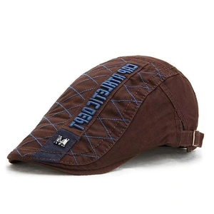 Detail of dark brown newsboy hat with blue quilting and embroidered CUB WHITE CDEBT logo