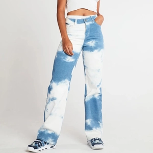 Detail of high-waisted wide-leg denim pants featuring artistic blue and white cloud print