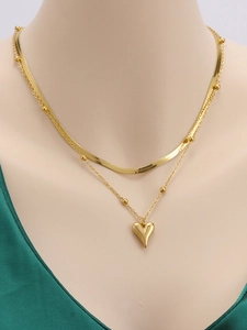 Dettaglio della collana a doppio strato dorata con maglia serpente e cuore