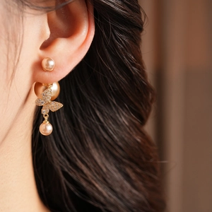 Detailed close-up of a vintage butterfly pearl earring with sparkling zirconia plating