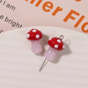Close-up of cute red dotted glass mushroom charms for DIY handmade earring accessories