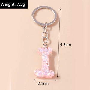 Detailed view of resin letter I keychain with pink sequins and measurement icons