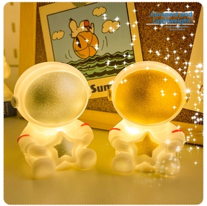 Detail showing two astronaut night lights with warm yellow and cool white LED glow effects