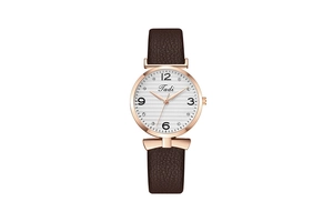 Detail of a rose gold quartz watch featuring a white textured dial and a bow accent on the strap