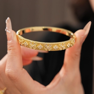 Detail of 18K gold-plated clover bangle with brushed finish and sparkling zircons