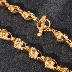 Close-up of golden punk skull necklace showing the detailed metal T-bar toggle clasp