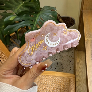 Pink cloud-shaped acetate hair claw with gold Moon, star, and moon diamond accents