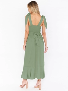 Detail of sage green dress featuring a smocked back and elegant bow tie shoulder straps