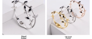Detail showing branch leaf bracelets in gold and silver finish with black enamel and zircons