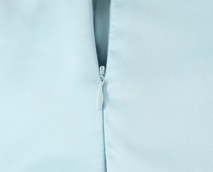 Close-up of invisible zipper and woven light blue fabric texture on sexy bodycon dress
