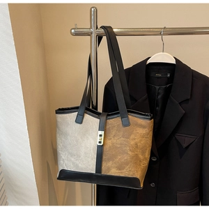Detailed view of bicolor large tote bag styled with a blazer on a chrome rack
