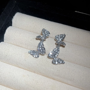 Detailed close-up of sparkling silver butterfly earrings with full zircon stones