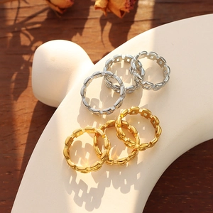 Minimalist gold and silver hollow chain rings displayed on white art props in natural light