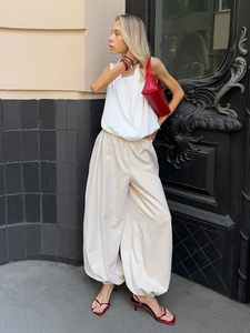 Outdoor shot of stylish high-waisted cotton lantern pants paired with a white halter top
