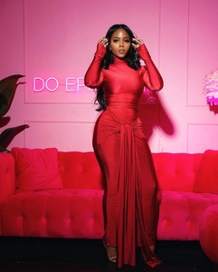 Détail d'une robe rouge moulante longue avec un drapé élégant à la taille en tissu soyeux