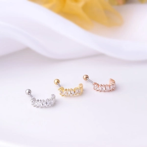 Macro view of curved ear studs in silver, gold and rose gold with rectangular crystals