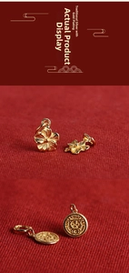 Detailed macro view of gold-plated flower charm and lucky tiger pendant for jewelry making