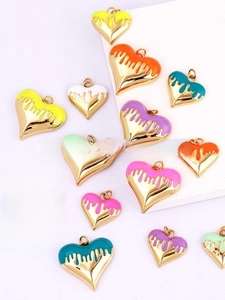 Macro shot of colorful enamel heart pendants with gold-plated edges for DIY jewelry making
