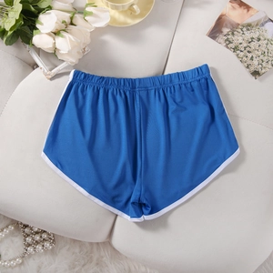 Detail of blue athletic shorts with white trim and elastic waistband on soft fabric
